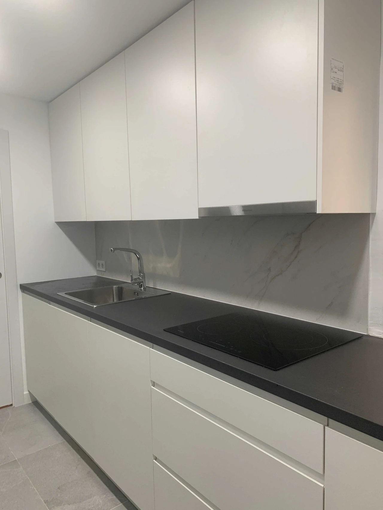 Cocina blanca con encimera efecto mármol y vitrocerámica
