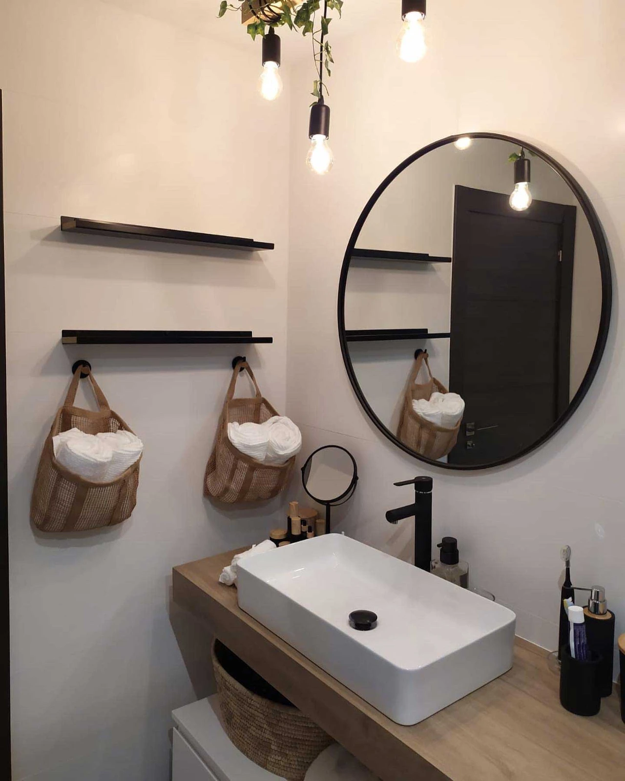 Lavabo sobre encimera de madera con espejo redondo