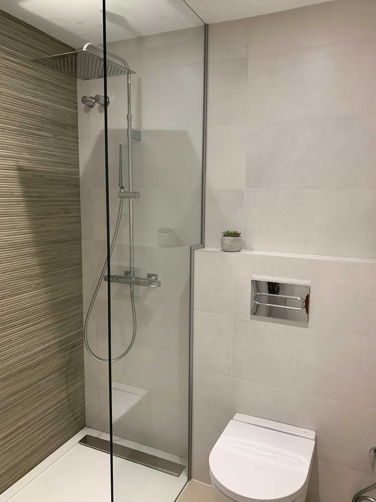 Ducha con pared de relieve y sanitario suspendido
