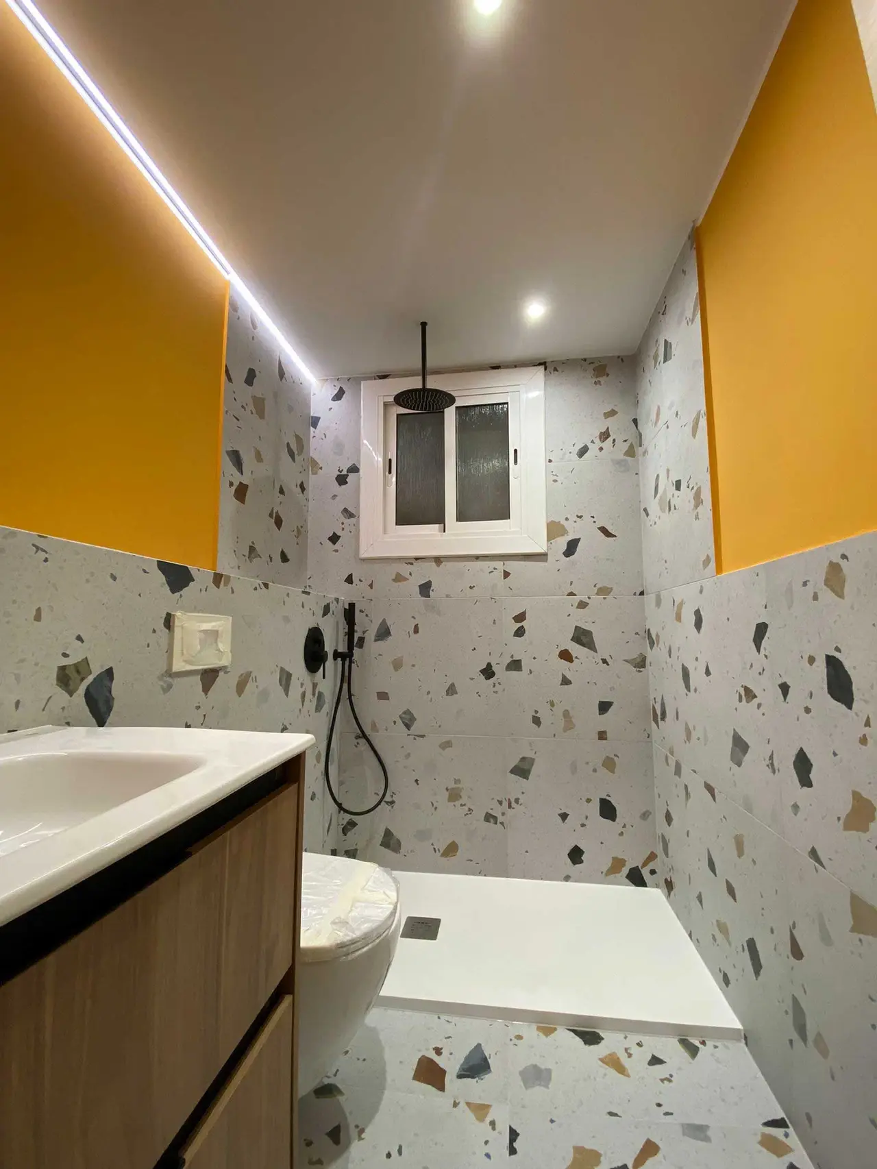 Baño con paredes naranjas y suelo de terrazo