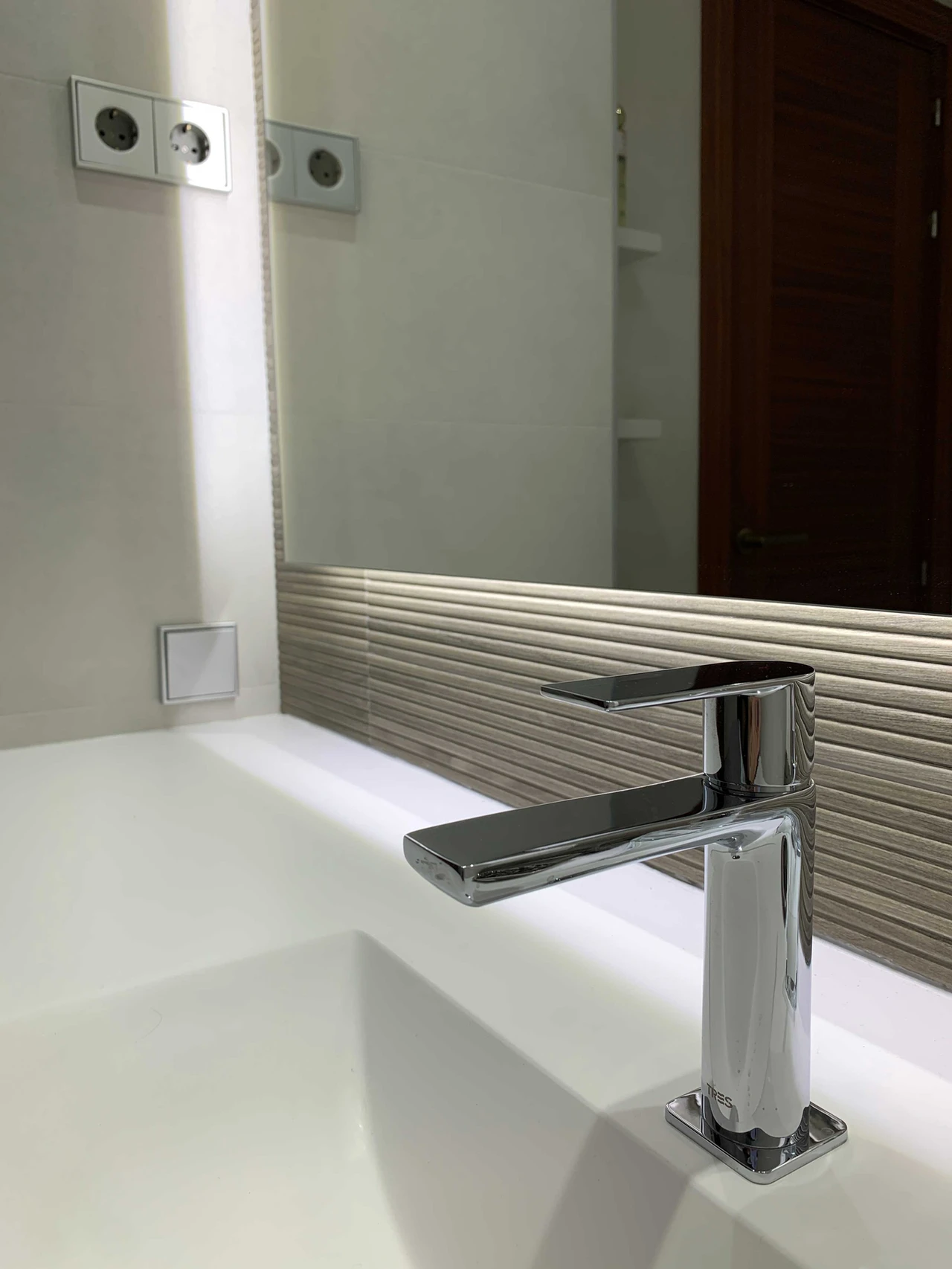 Lavabo con grifo de diseño cromado en baño moderno
